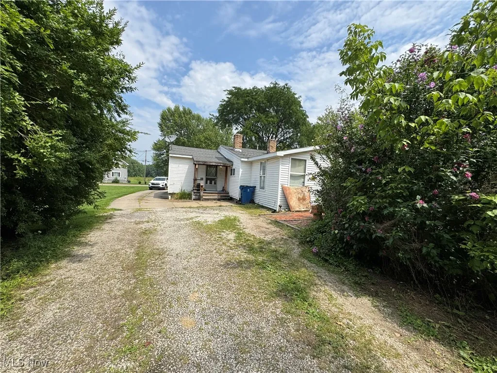 View of front of house featuring driveway and a chimney