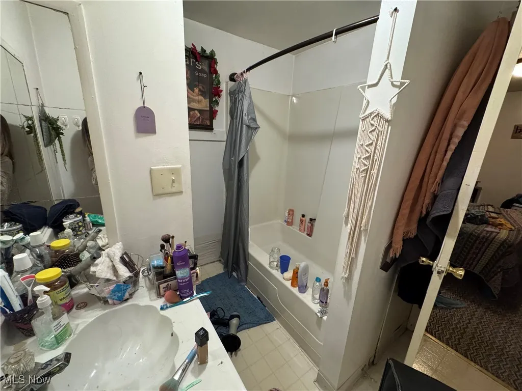 Bathroom with shower / bathtub combination with curtain and vanity