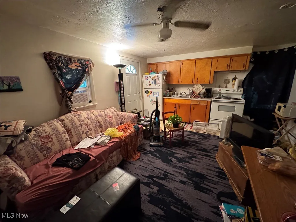 Living area featuring a textured ceiling and a ceiling fan