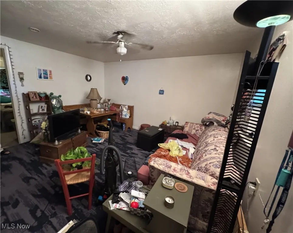 Bedroom featuring a textured ceiling, ceiling fan, and a desk