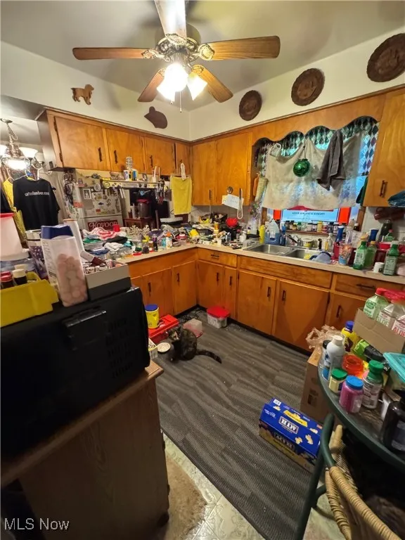Kitchen with brown cabinets, light countertops, and a ceiling fan