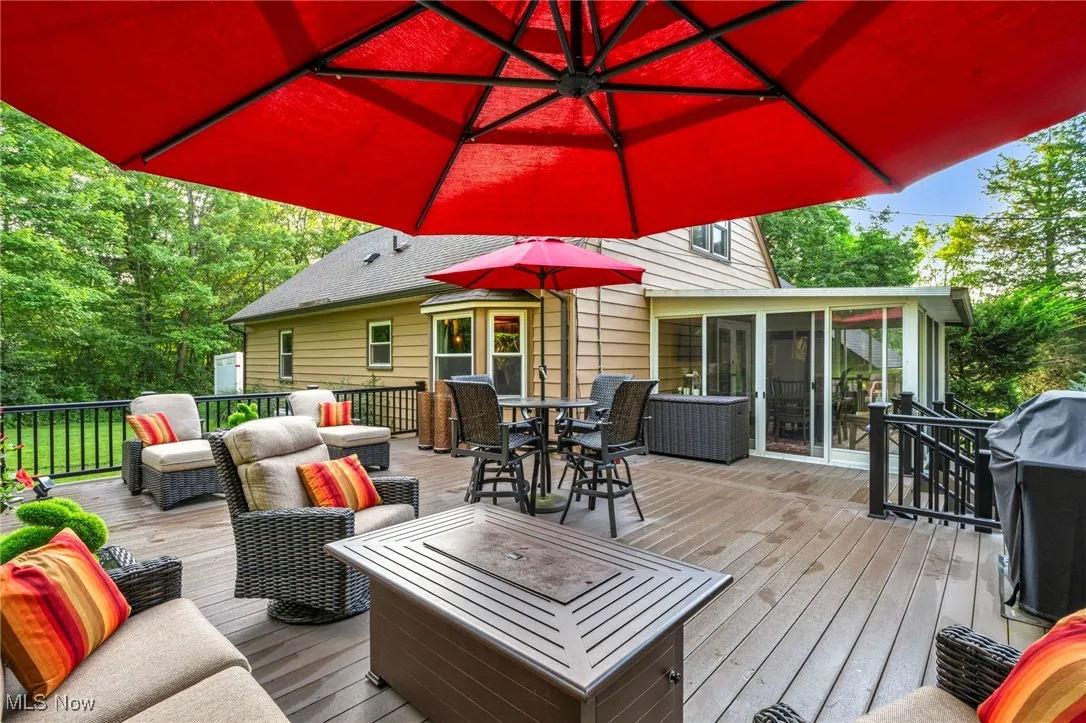 Deck featuring a sunroom, outdoor dining area, area for grilling, and an outdoor hangout area