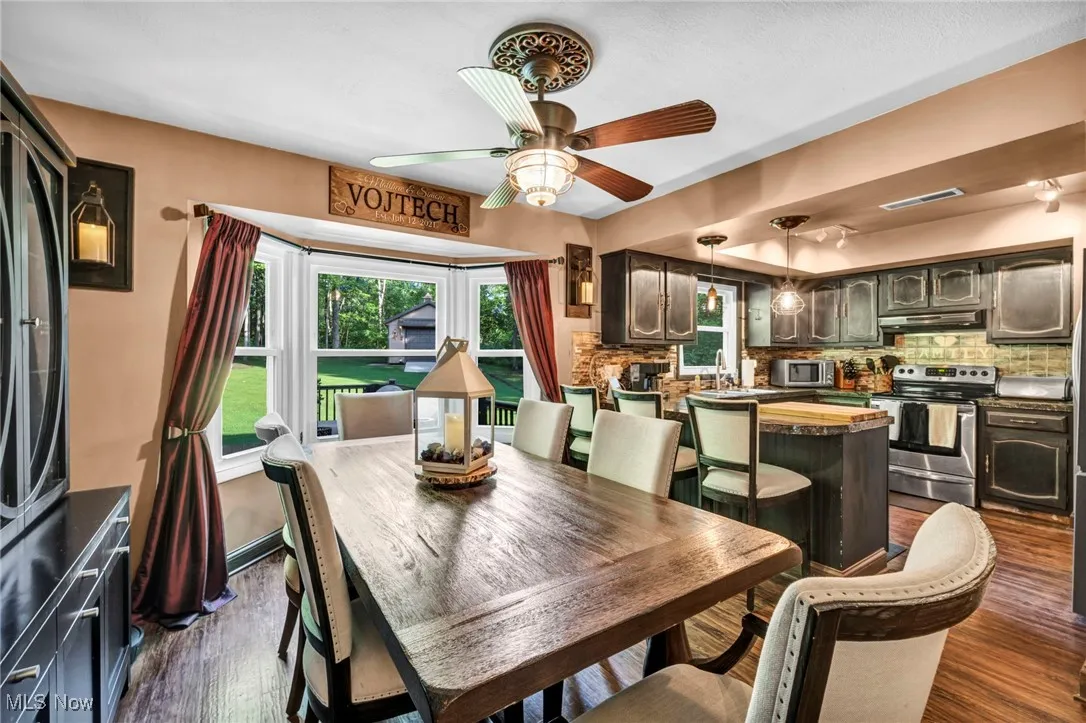 Dining space featuring dark wood-type flooring and ceiling fan