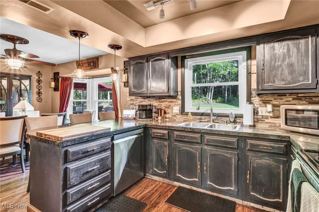 Kitchen with a peninsula, decorative backsplash, plenty of natural light, and dark wood finished floors