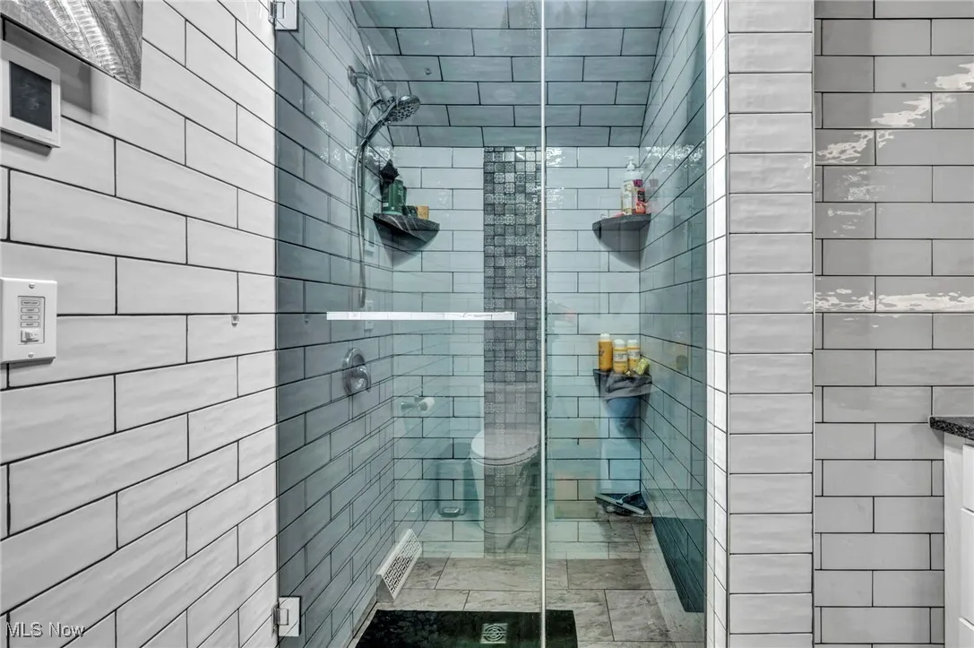 Full bathroom with a tile shower and toilet
