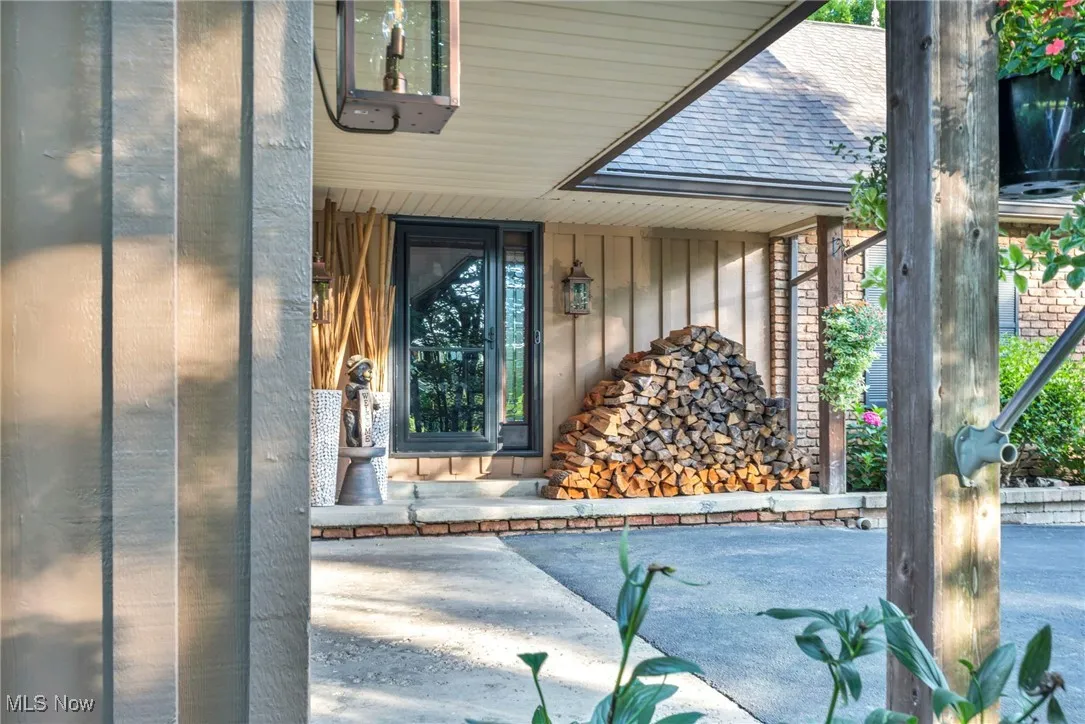 View of exterior entry featuring roof with shingles and board and batten siding