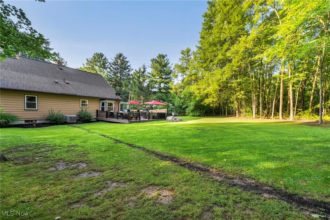 View of green lawn with a wooden deck