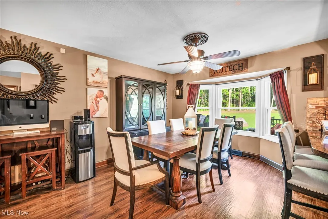 Dining space with healthy amount of natural light, wood finished floors, and a ceiling fan