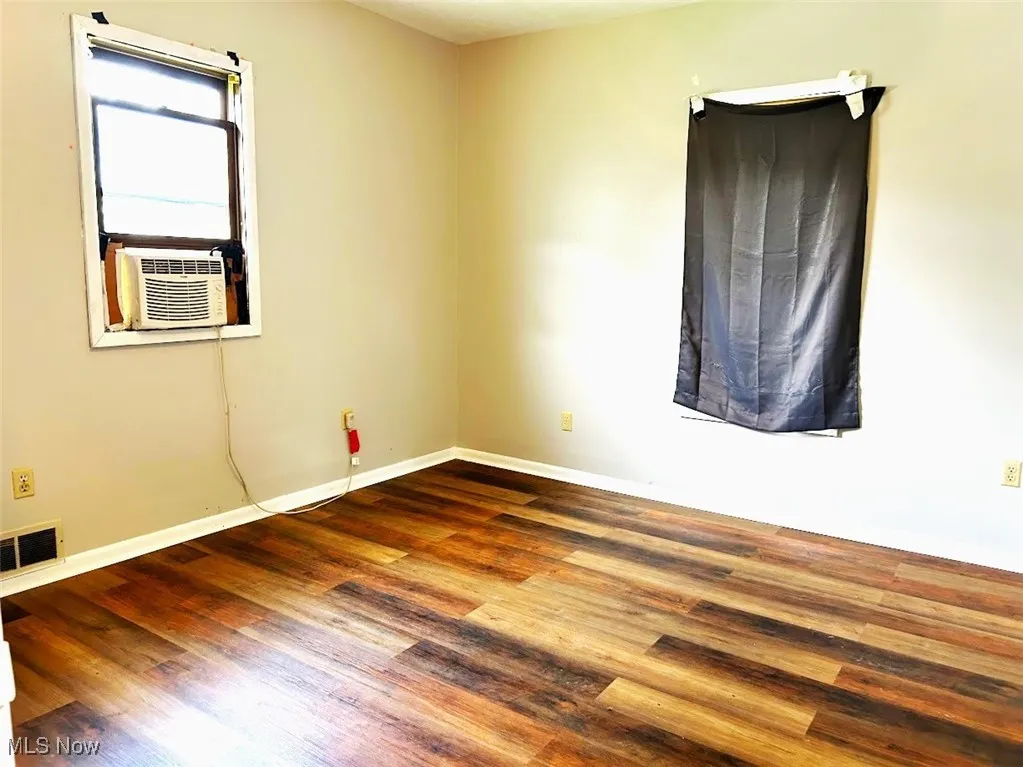 Spare room featuring wood finished floors and cooling unit