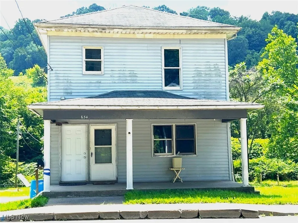 View of front of house featuring roof with shingles and covered porch