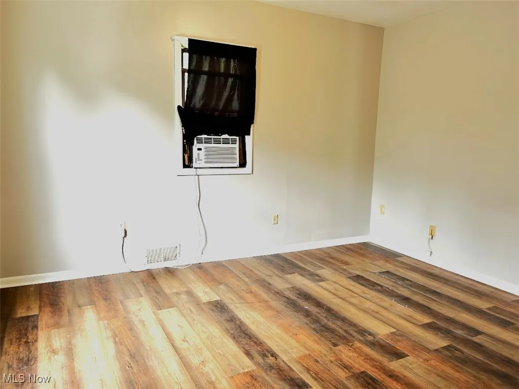 Spare room with wood finished floors and baseboards