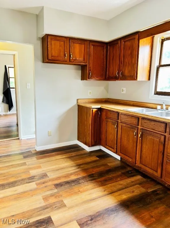 Kitchen with wood finished floors, brown cabinets, and light countertops