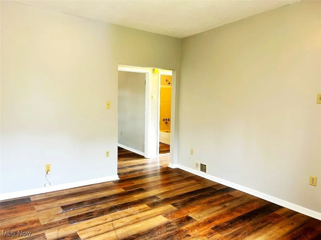 Spare room featuring wood finished floors and baseboards