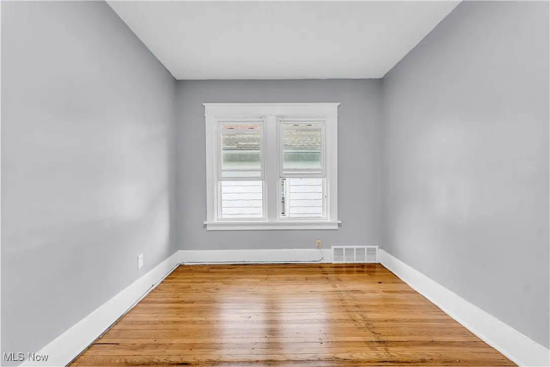 Unfurnished room with wood-type flooring and baseboards