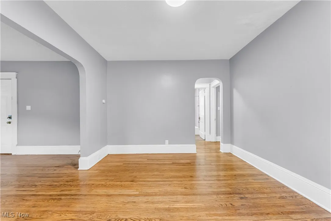 Unfurnished room featuring light wood-type flooring and arched walkways