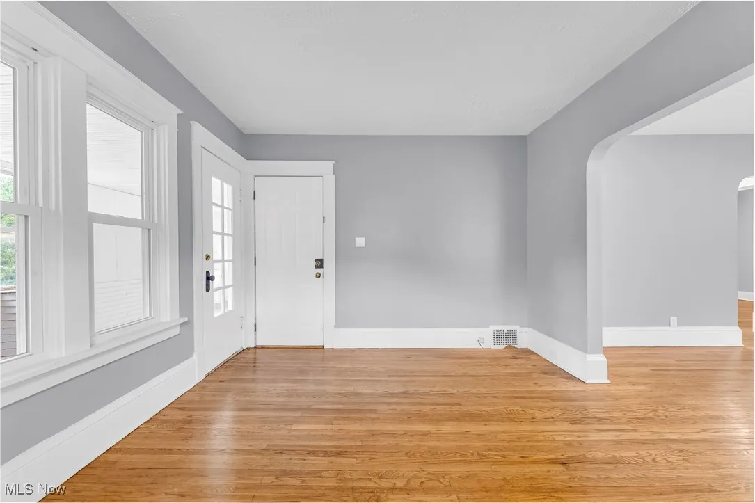Entrance foyer with light wood-style flooring, plenty of natural light, and arched walkways
