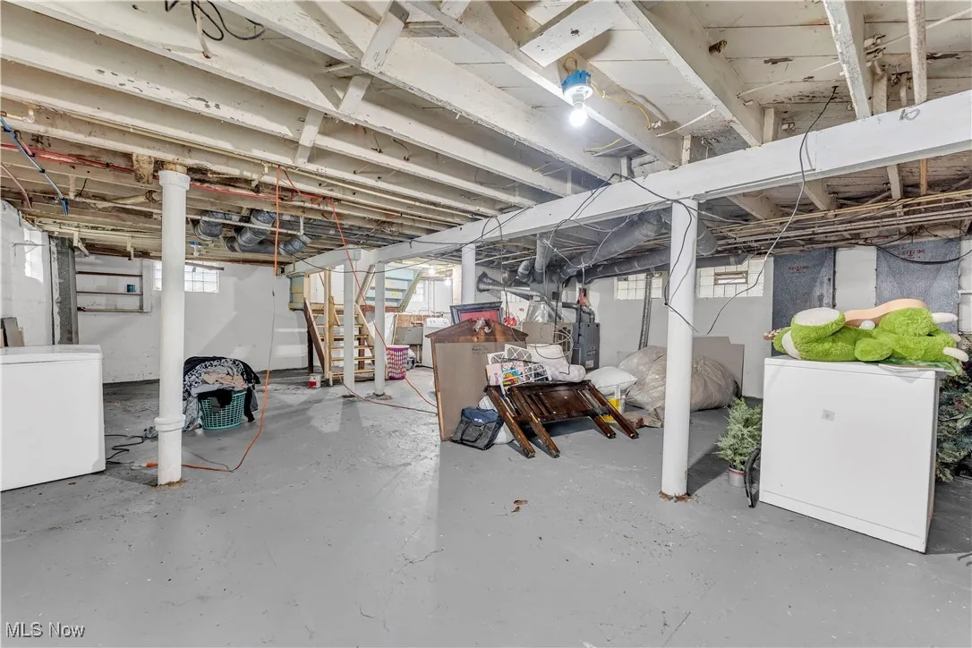 Below grade area featuring fridge, washer / clothes dryer, and stairway