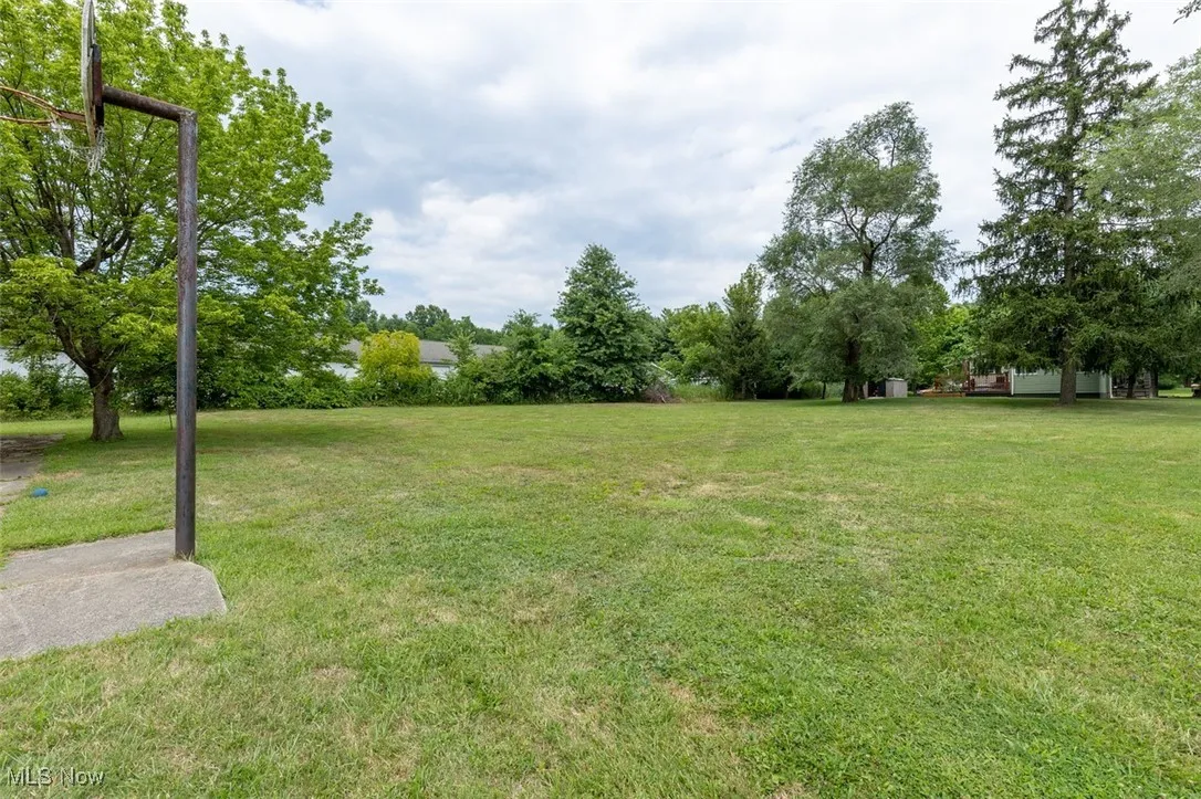 View of green lawn with view of scattered trees