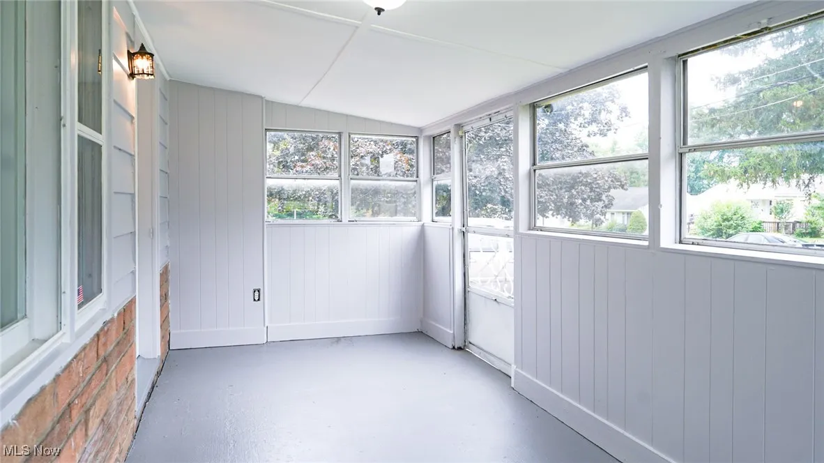Unfurnished sunroom featuring vaulted ceiling