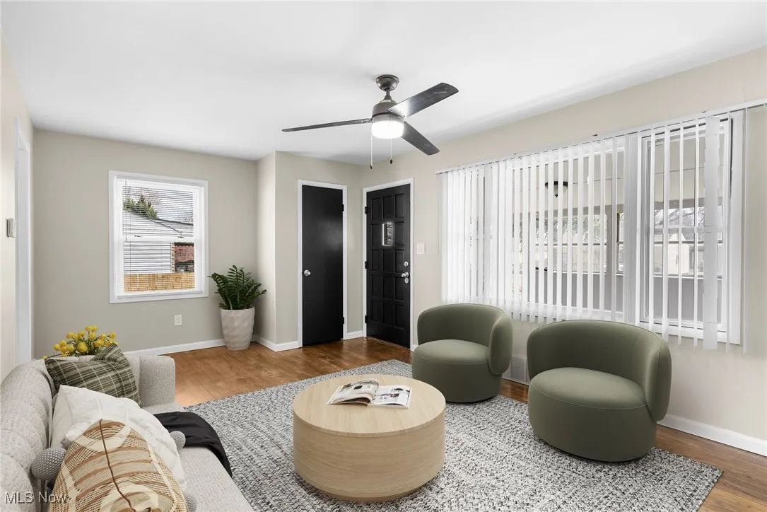 Living area with a ceiling fan, baseboards, and wood finished floors