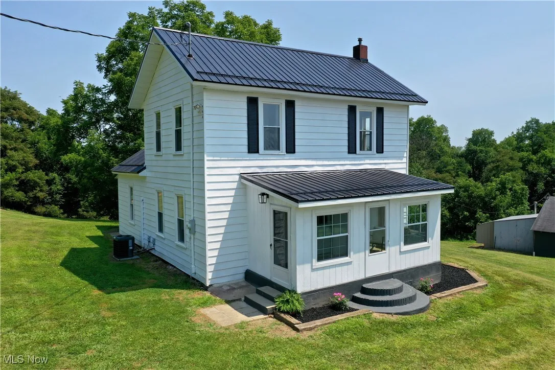Front view of property featuring a metal roof, a standing seam roof, and entry steps