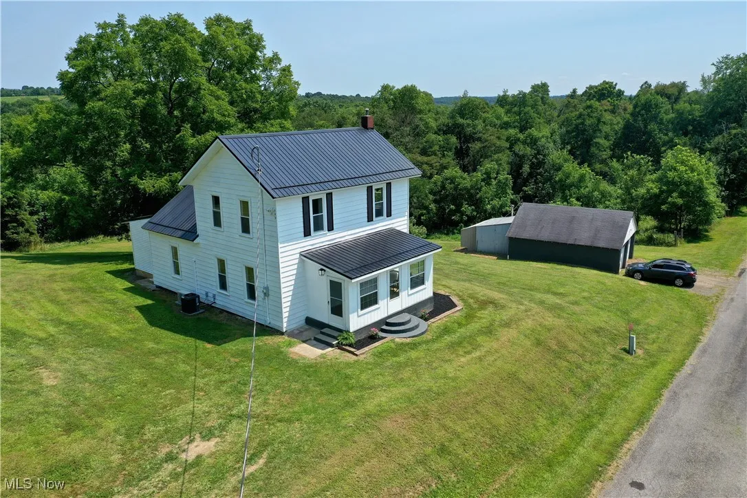 View of front of property with a metal roof, a front lawn, a standing seam roof, and a chimney