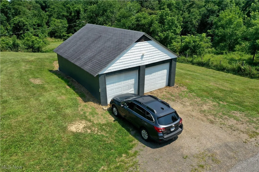Detached garage featuring a forest view