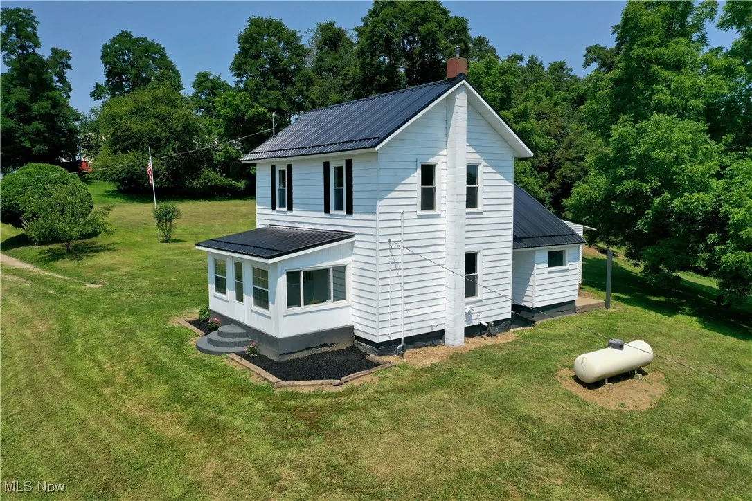 View of home's exterior with a metal roof, a yard, and a chimney