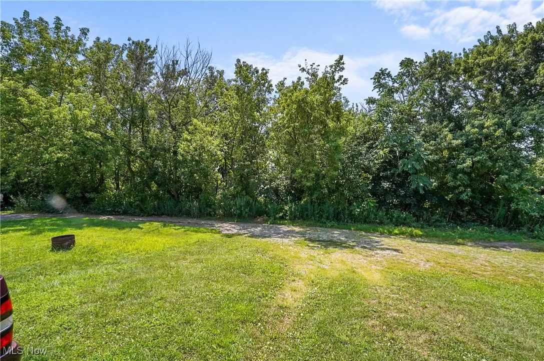 View of grassy yard featuring a forest view