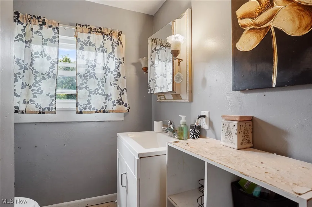 Half bathroom with baseboards and vanity