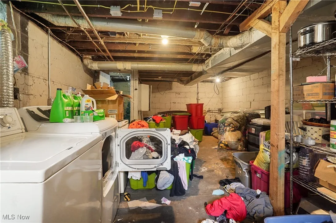 Unfinished below grade area featuring washing machine and dryer