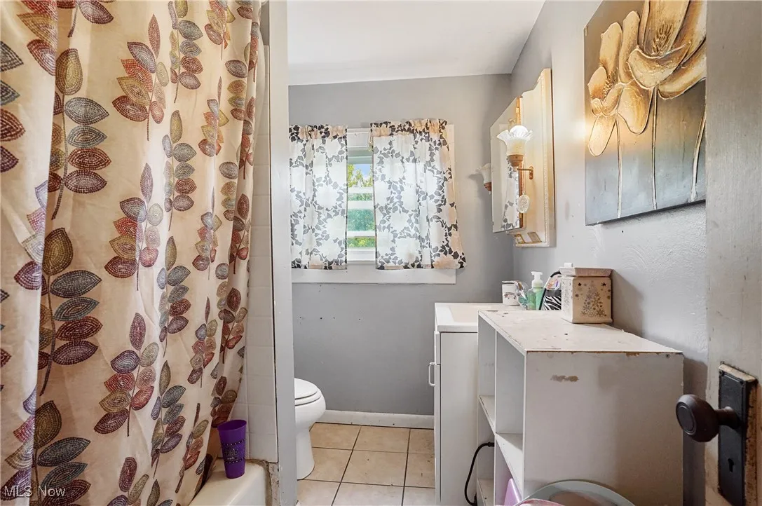Bathroom with tile patterned flooring and shower / bath combo