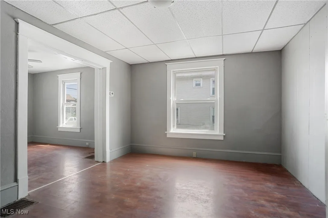 Empty room featuring a paneled ceiling and wood finished floors