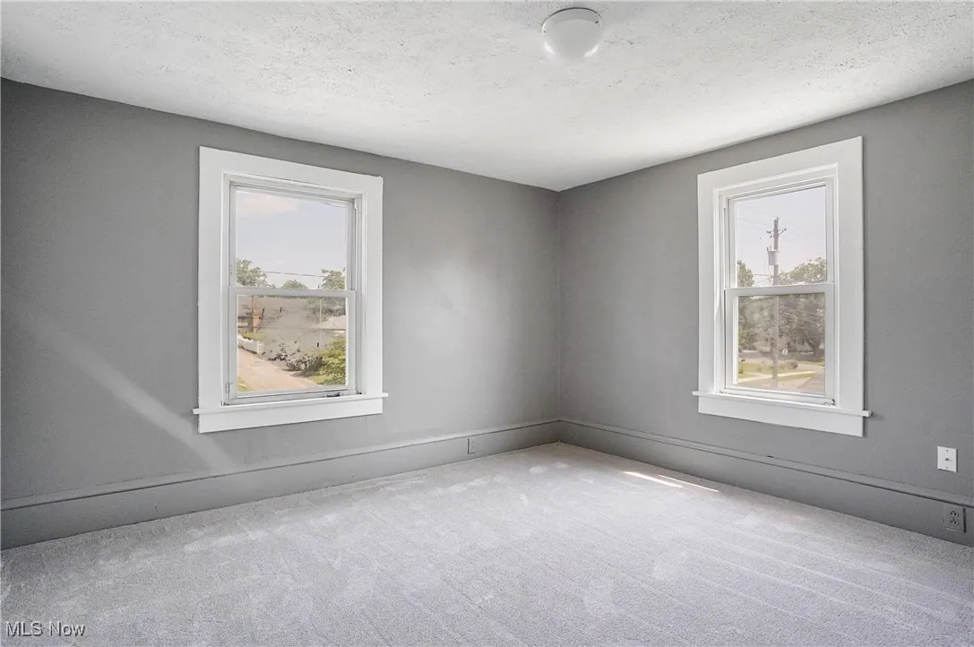 Unfurnished room featuring carpet and a textured ceiling