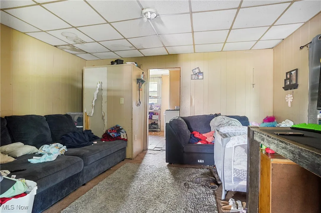 Living area with wood walls and a drop ceiling
