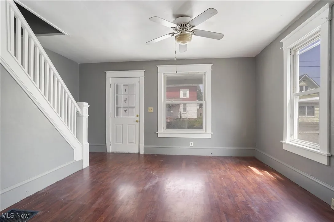 Entryway with wood finished floors, stairway, and a ceiling fan