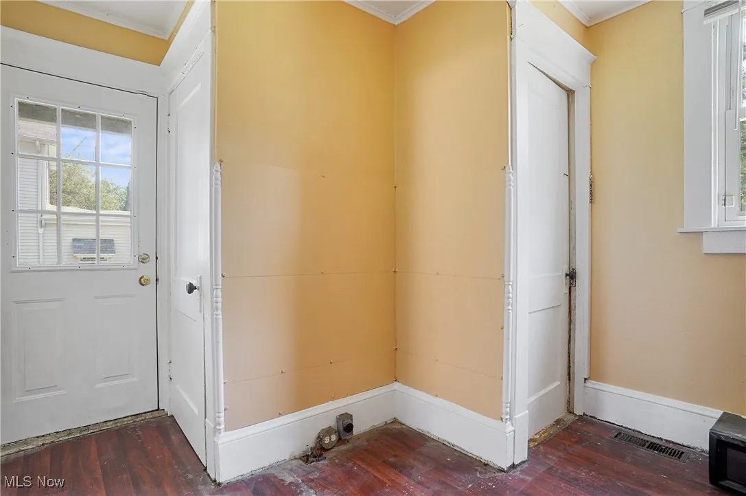 Entryway featuring healthy amount of natural light, dark wood finished floors, and ornamental molding