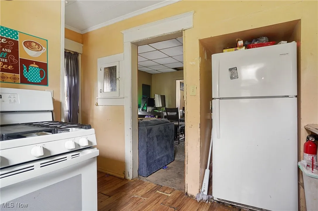 Kitchen with white appliances and hardwood / wood-style floors