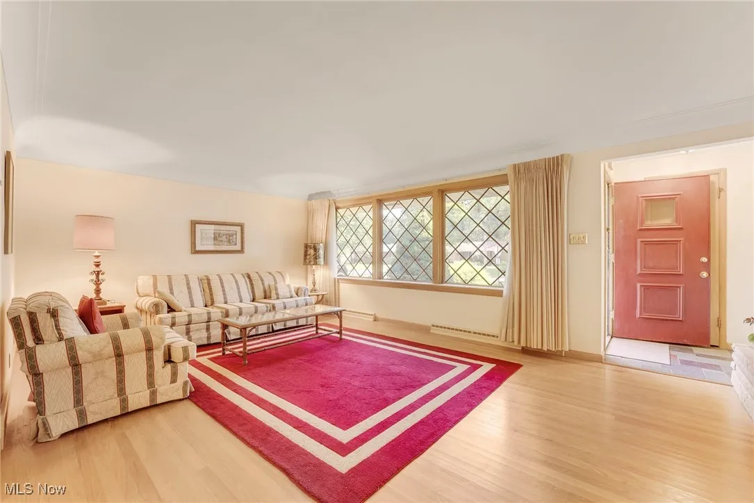 Spacious living room with beautiful cove ceiling and a striking stone wood-burning fireplace