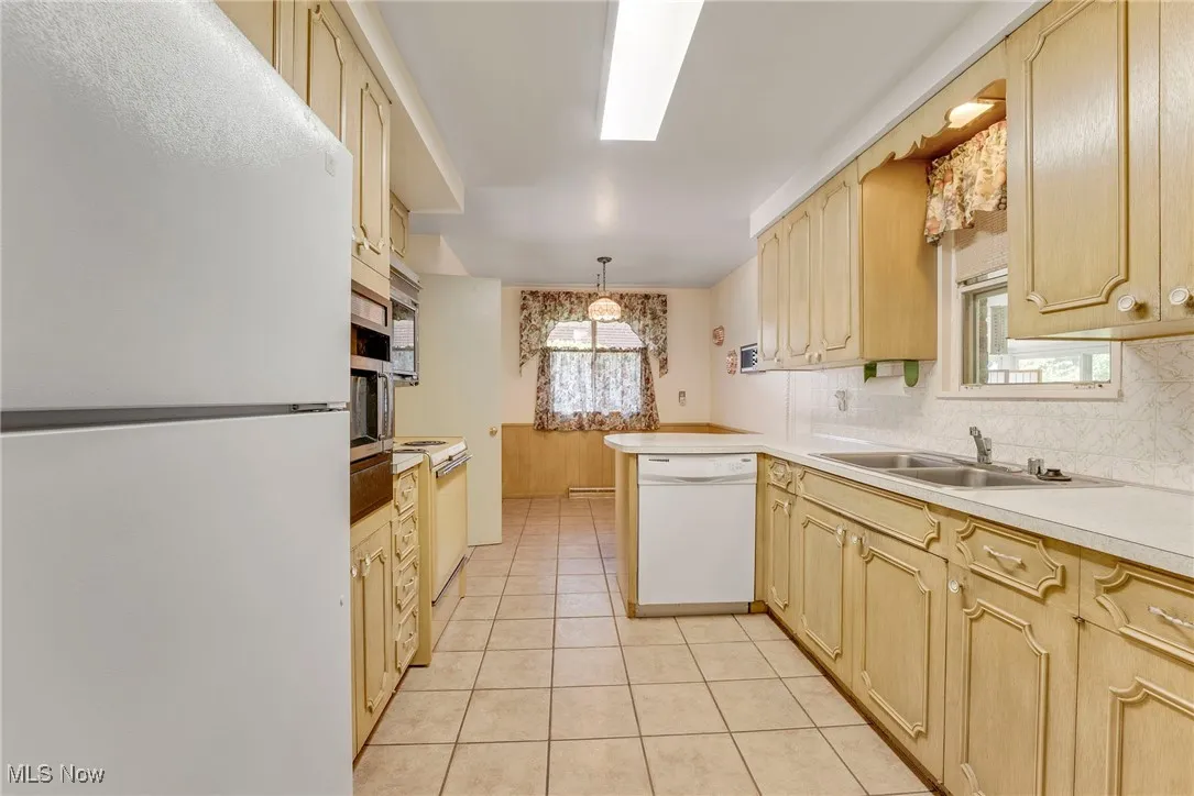 The kitchen features ample cabinet space, a tile floor, and a cozy eat-in area