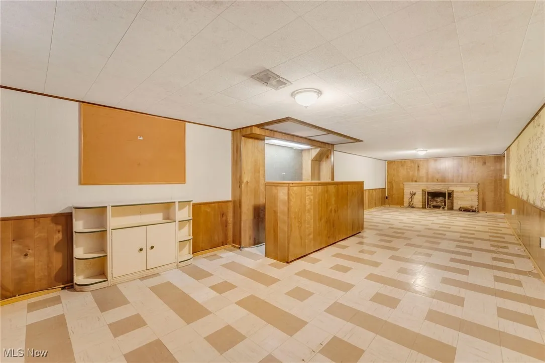 Lower level with wood-paneled walls and a built-in bar