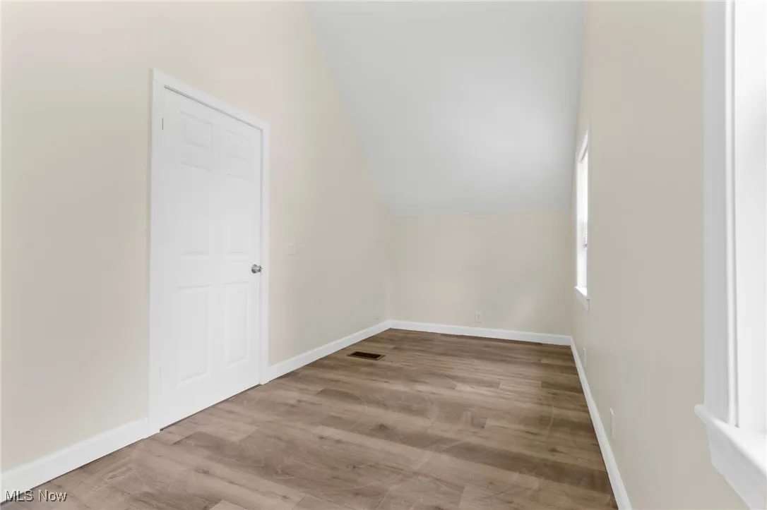 Bonus room with lofted ceiling and wood finished floors