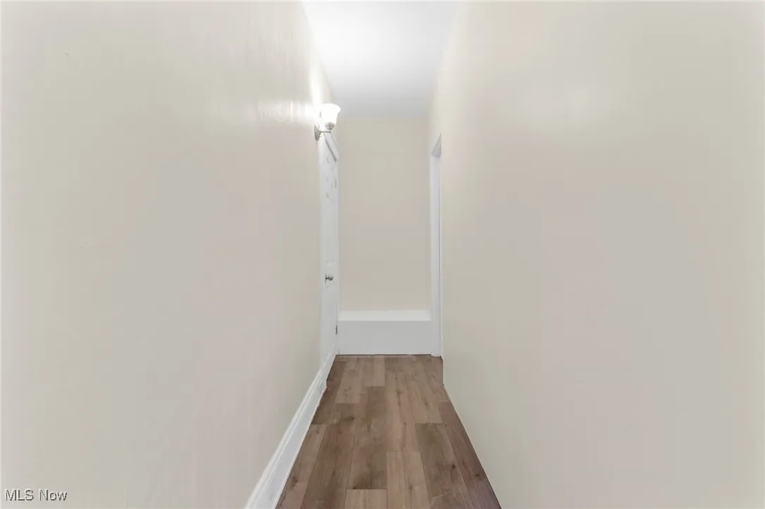 Hallway featuring wood finished floors and baseboards