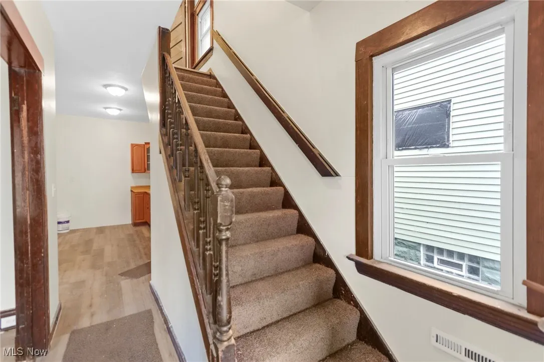 Stairway featuring wood finished floors