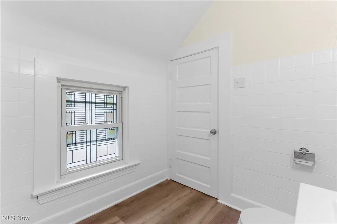 Bathroom with wood finished floors and vaulted ceiling
