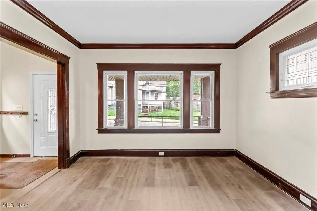 Entrance foyer featuring light wood-style flooring, plenty of natural light, and crown molding