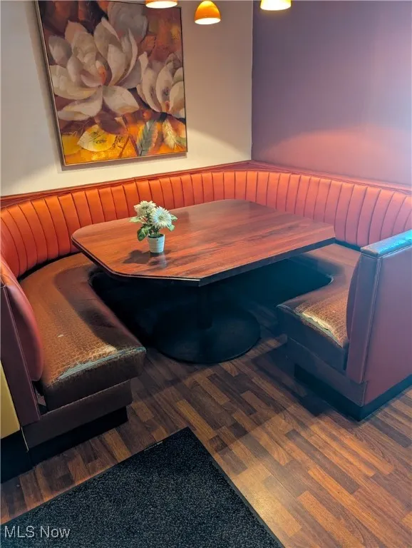Dining space with radiator, a wainscoted wall, and wood finished floors