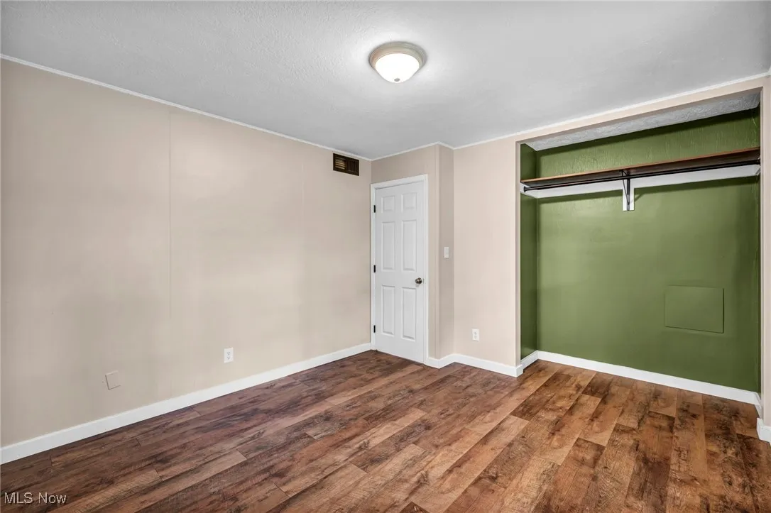 Unfurnished bedroom featuring wood finished floors and a textured ceiling