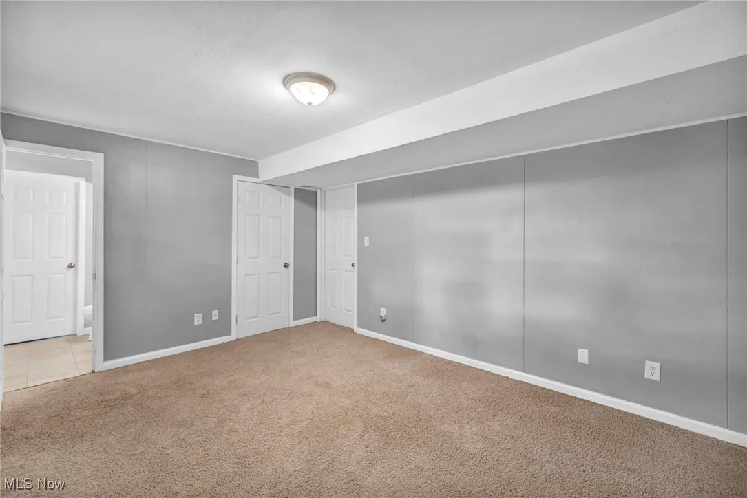 Unfurnished bedroom with carpet flooring and baseboards