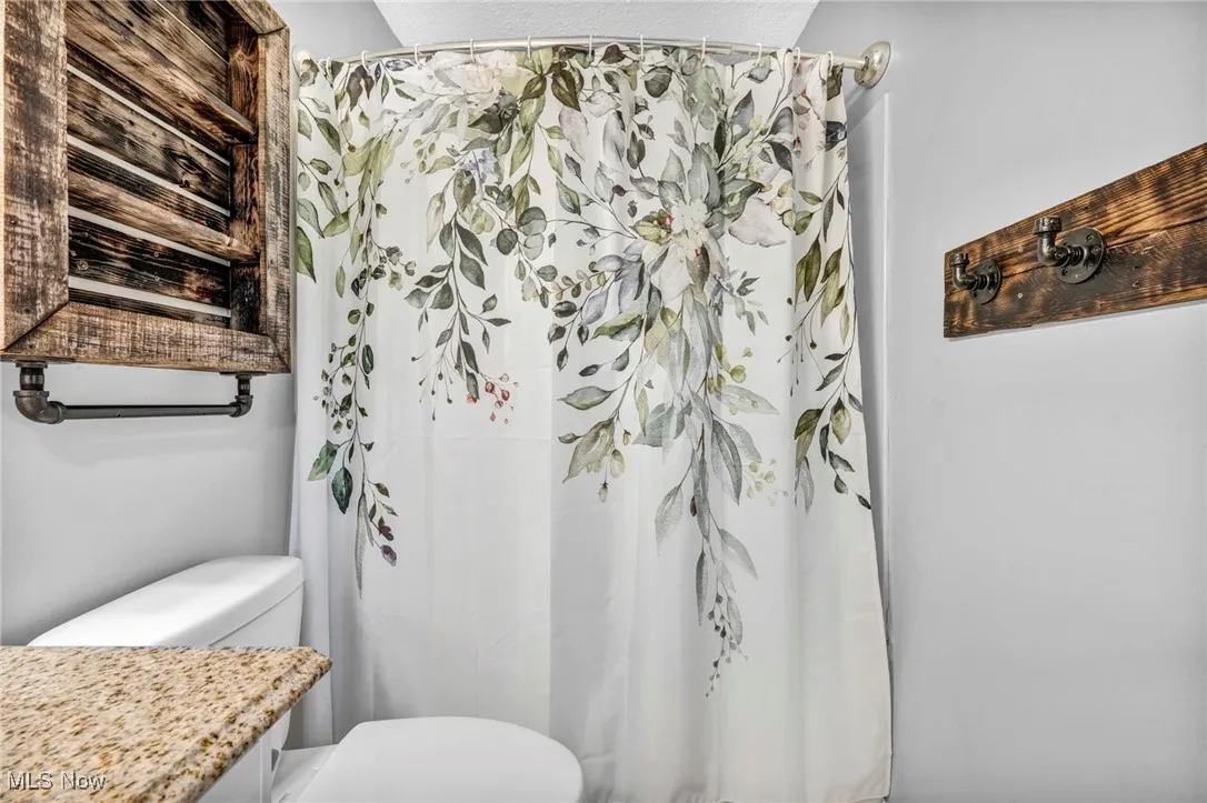 Bathroom with toilet and a shower with curtain